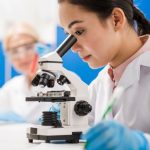 girl scientist using microscope