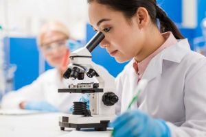 girl scientist using microscope