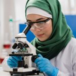 scientist in hijab using microscope