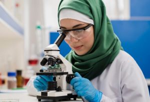 scientist in hijab using microscope